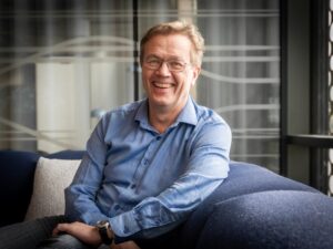 Styremedlem i Neas, Trond Sæterøy sitter i en sofa og smiler mot kamera